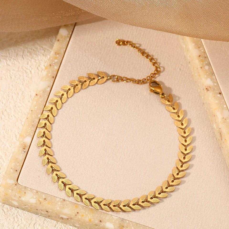 Gold necklace on a textured beige surface