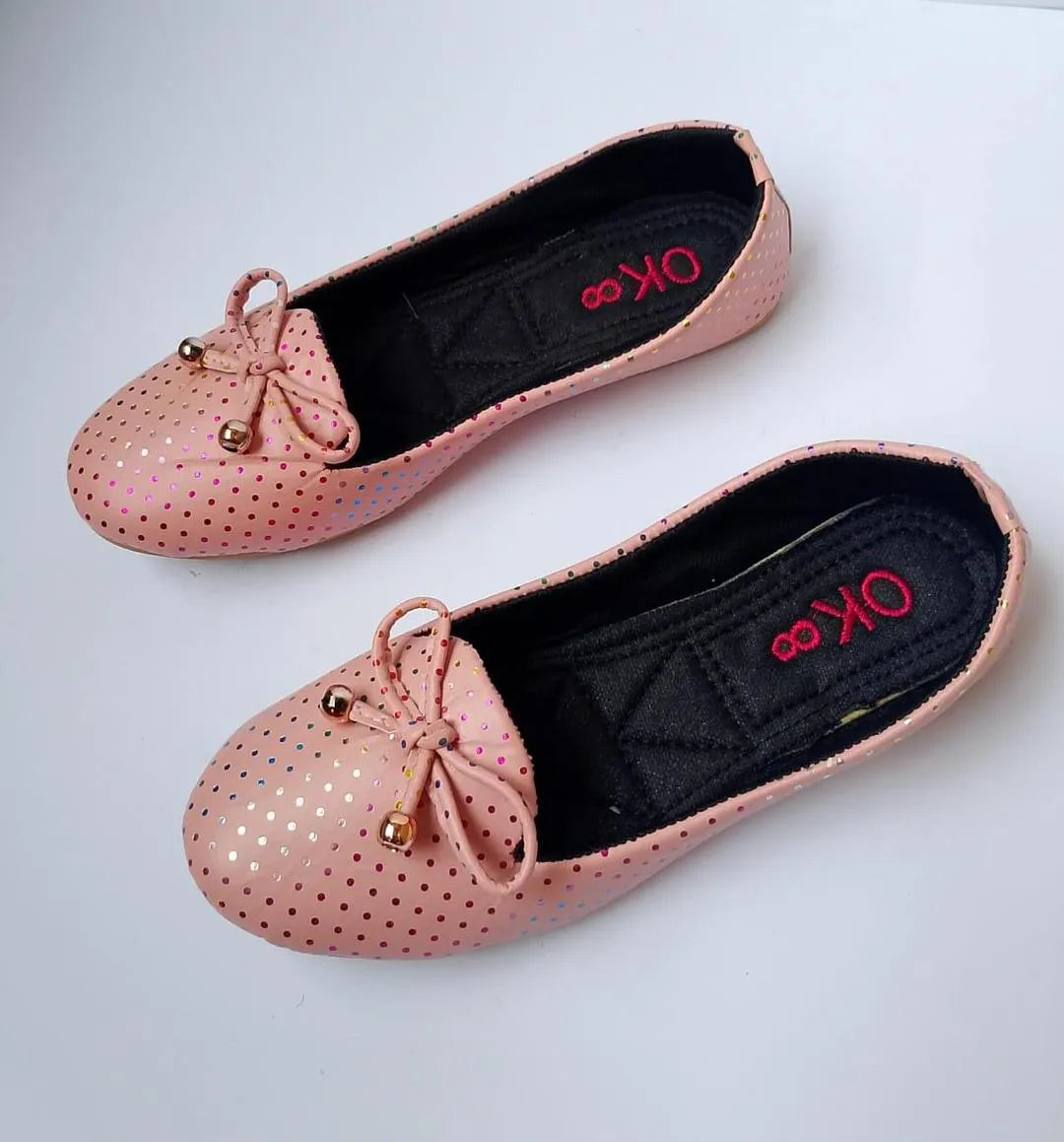 Pair of pink perforated shoes with decorative bows on a white background