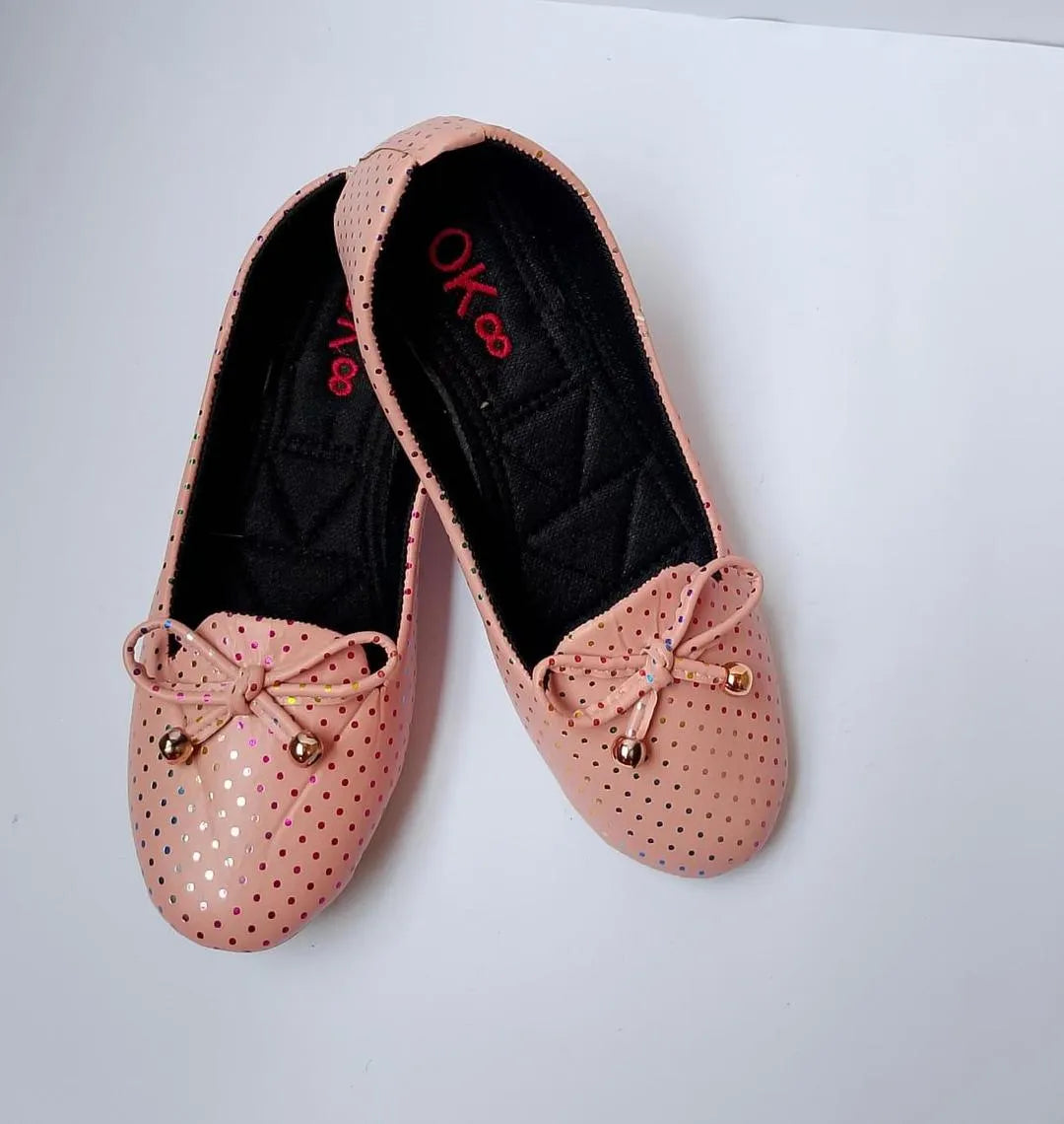 Pair of pink perforated shoes with decorative bows on a white background