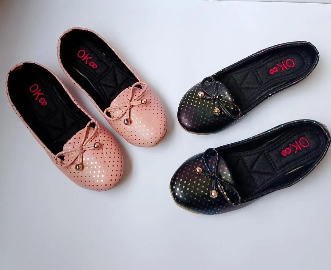 Two pairs of flat shoes, one pink and one black with gold accents, on a white background.