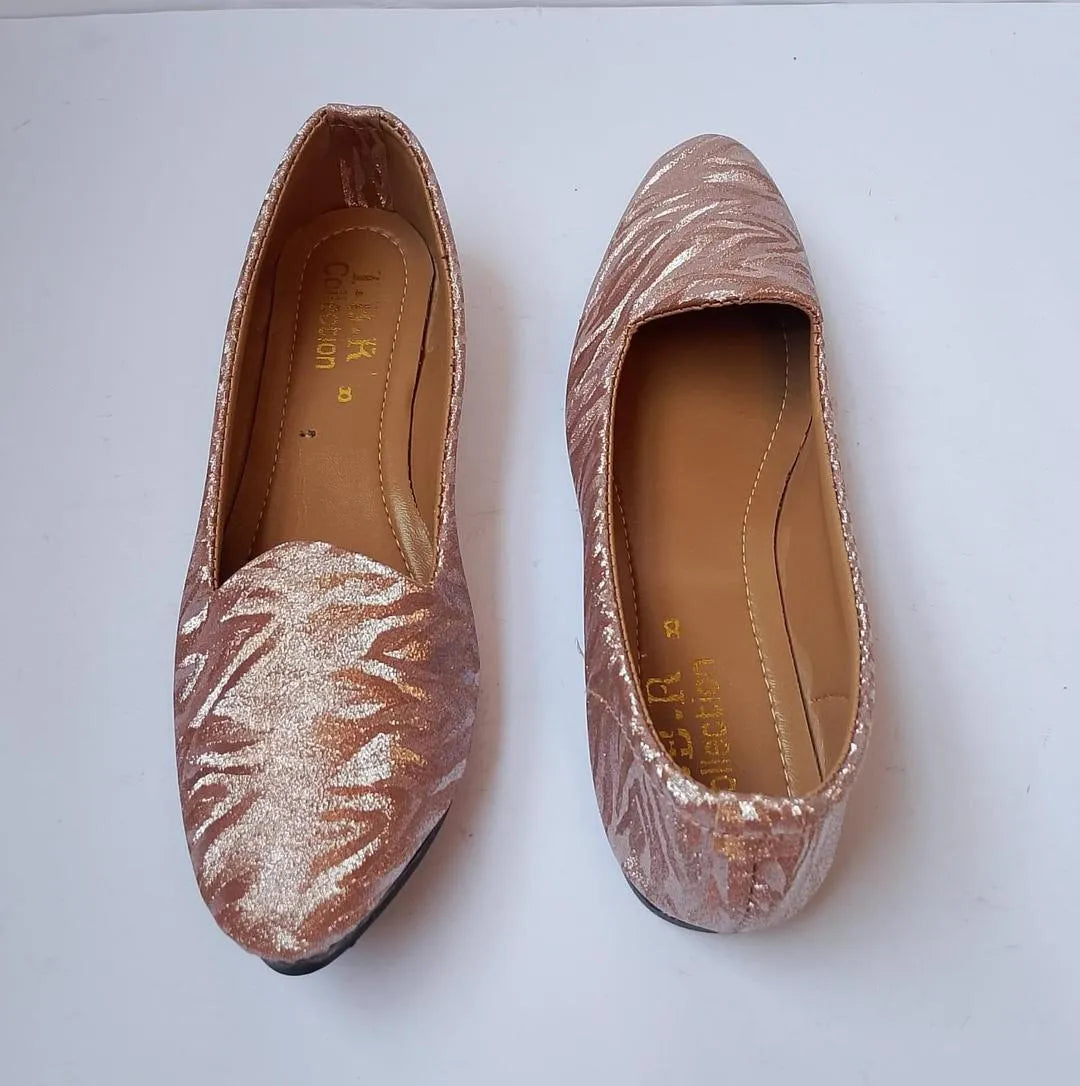 Pair of glittery pink flats on a white background