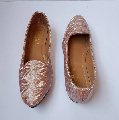 Pair of glittery pink flats on a white background