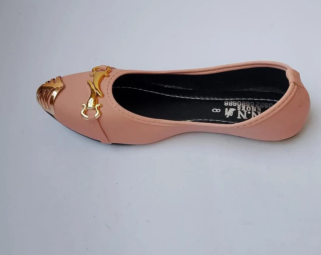 Pink flat shoe with gold accents on a light gray background