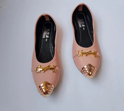 Pair of pink shoes with gold accents on a light gray background