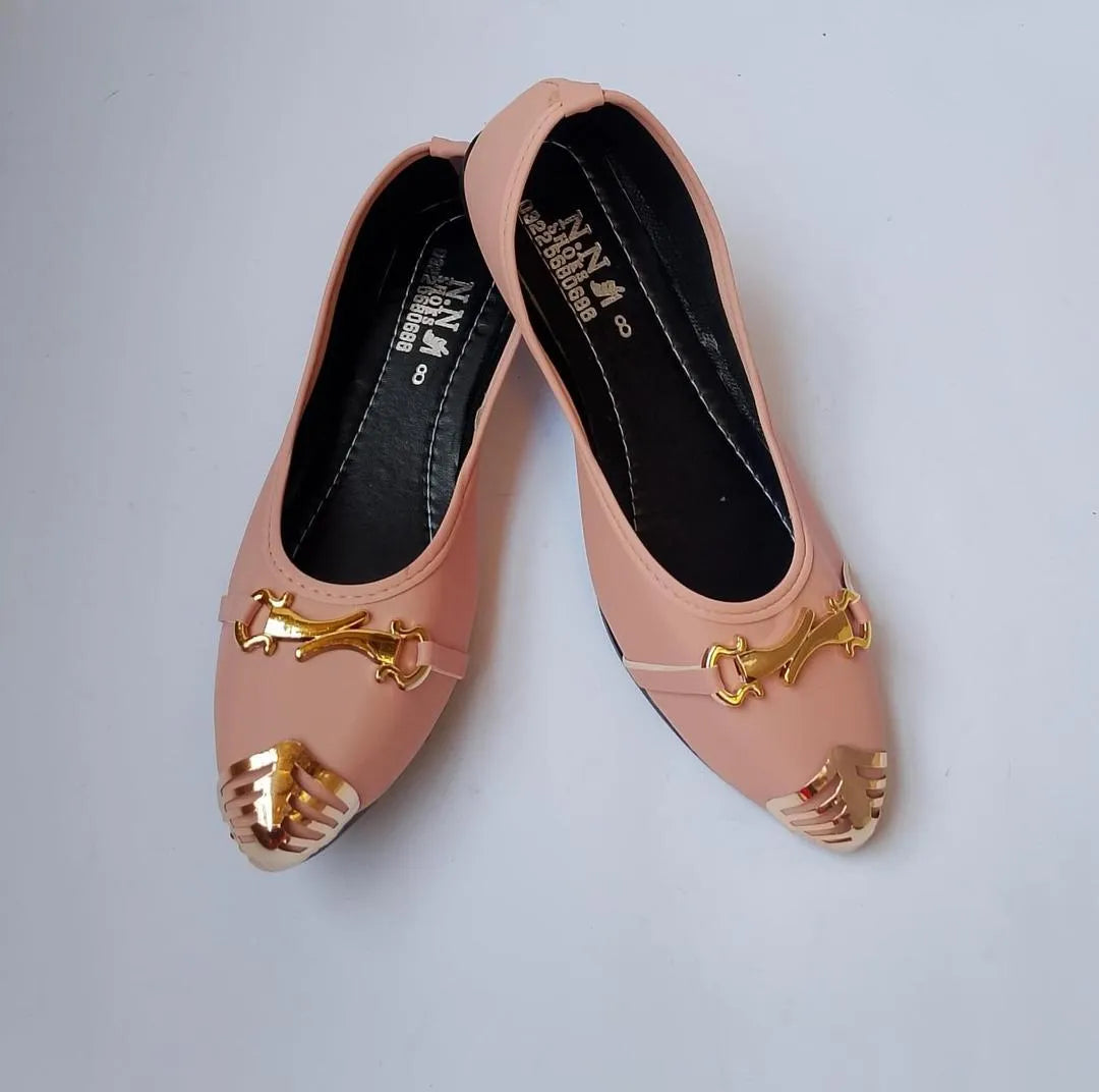 Pair of pink shoes with gold accents on a light gray background