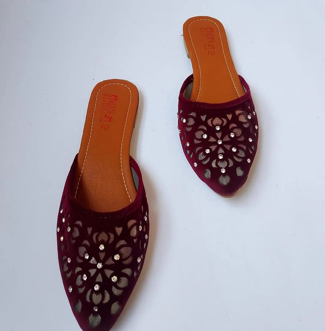 Pair of maroon slippers with cut-out designs on a white background
