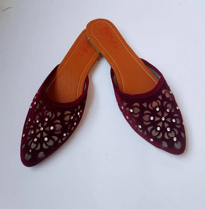Pair of maroon pointed-toe shoes with cut-out design on a white background