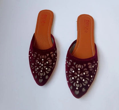 Pair of maroon slip-on shoes with cut-out design on a white background