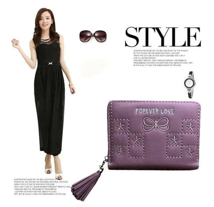 Woman in black dress with purple wallet, sunglasses, and watch on white background