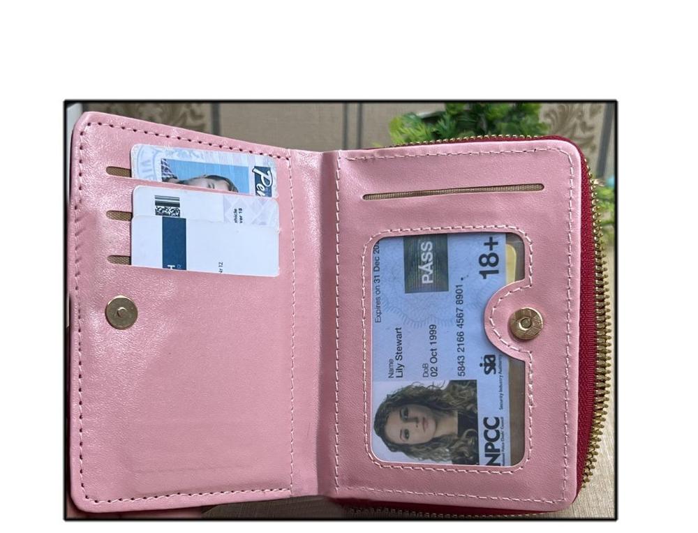 Pink wallet with cards and ID card inside on a white background