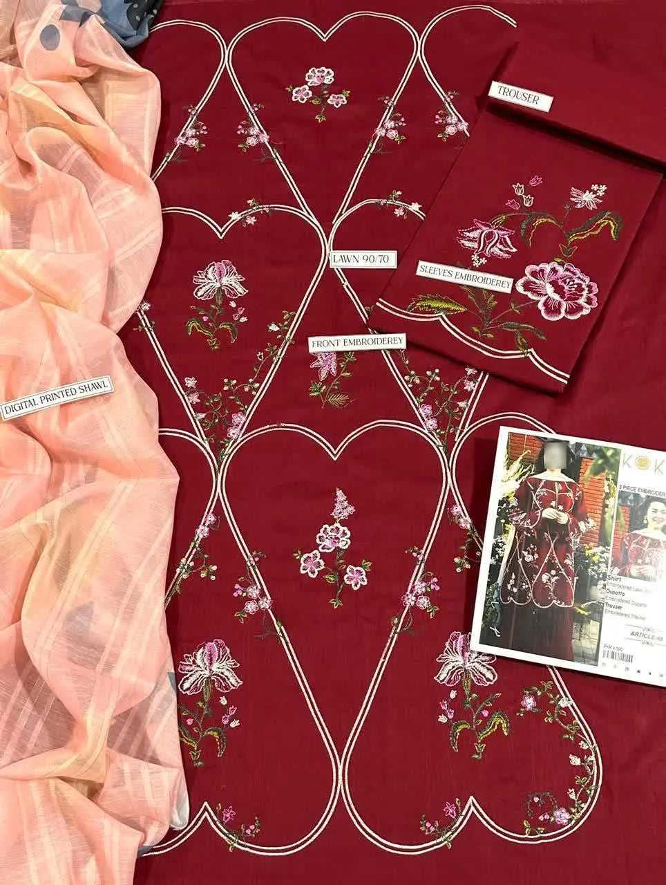 Red fabric with floral patterns and a pink sheer fabric on a table.