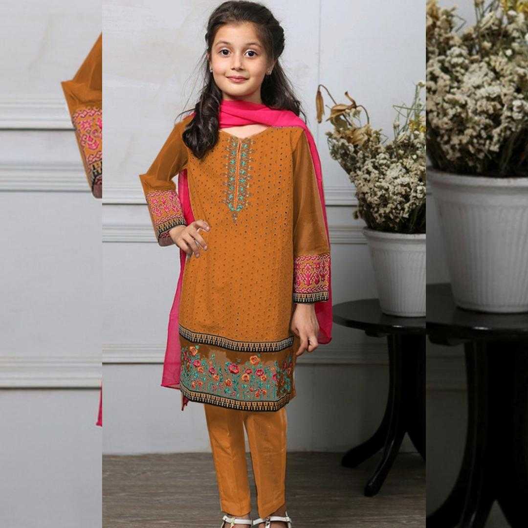 Young girl wearing an orange embroidered outfit with a pink scarf indoors.