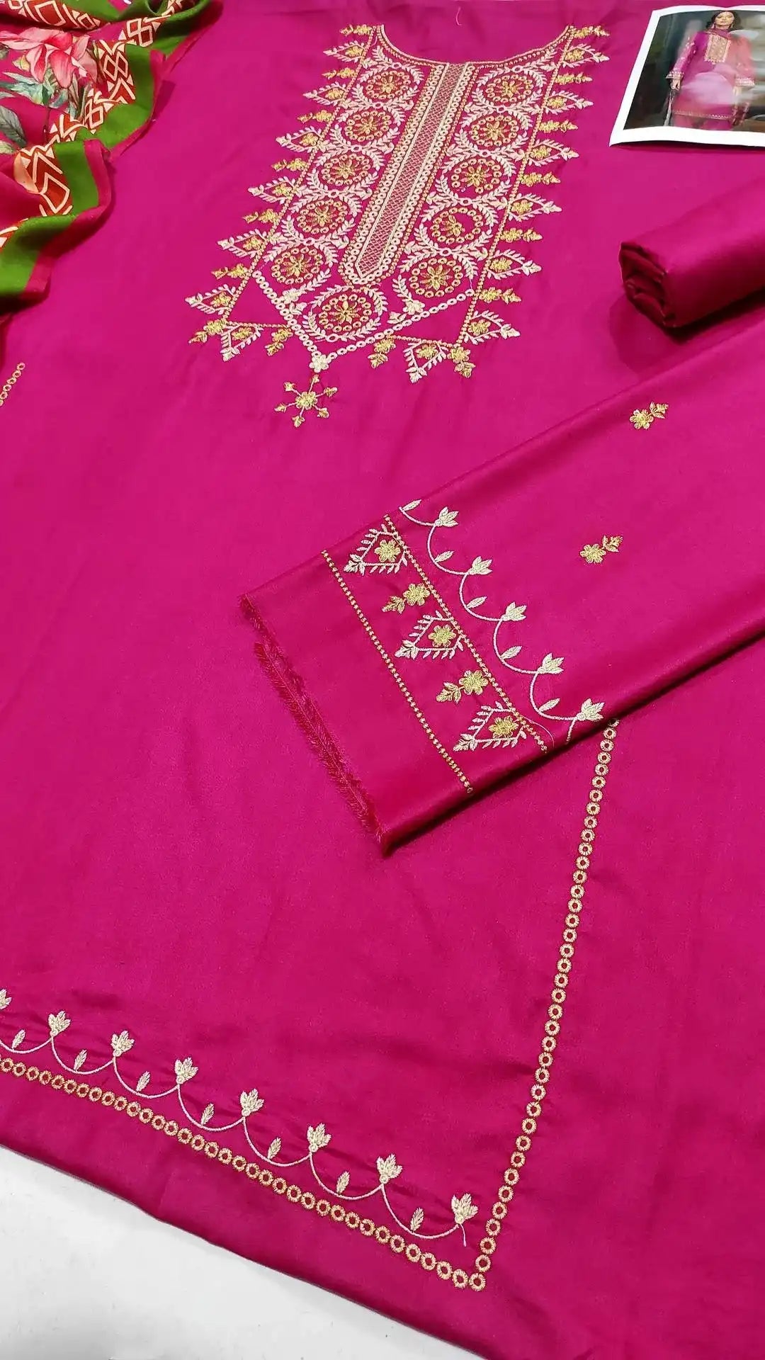 Pink embroidered fabric with intricate patterns on a white background