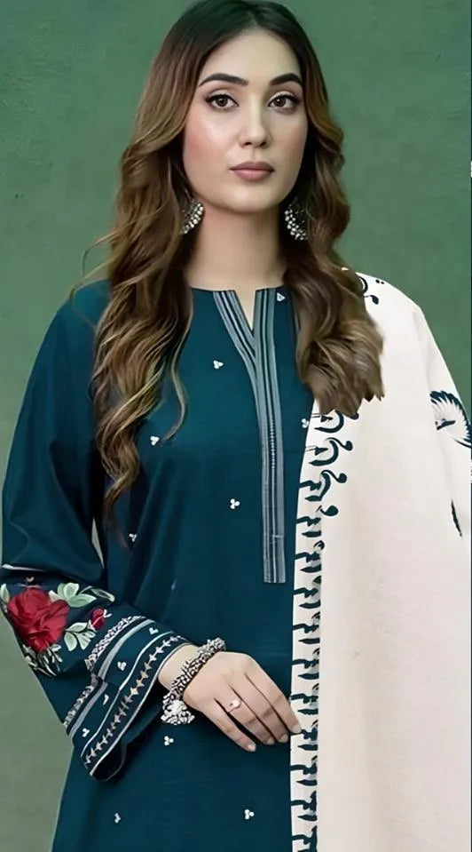 Woman wearing a teal outfit with floral sleeves and a light pink dupatta against a green background
