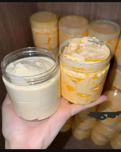 Hand holding a jar of creamy yellow substance with more jars in the background.