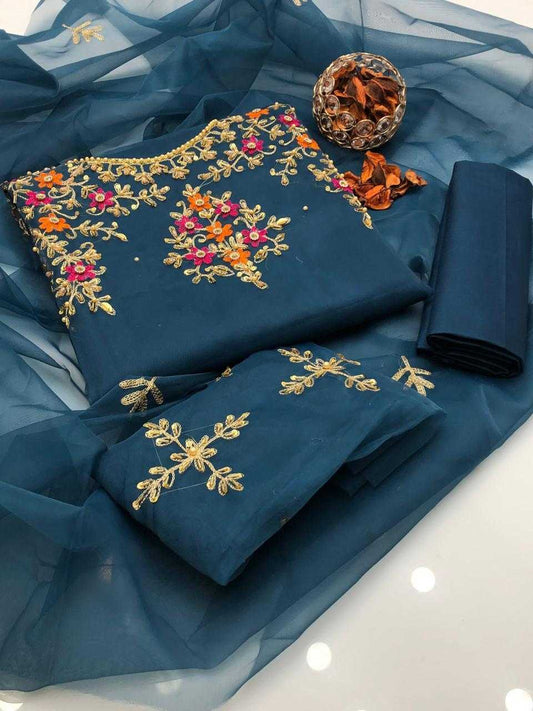 Blue embroidered fabric with gold and multicolor patterns on a white background