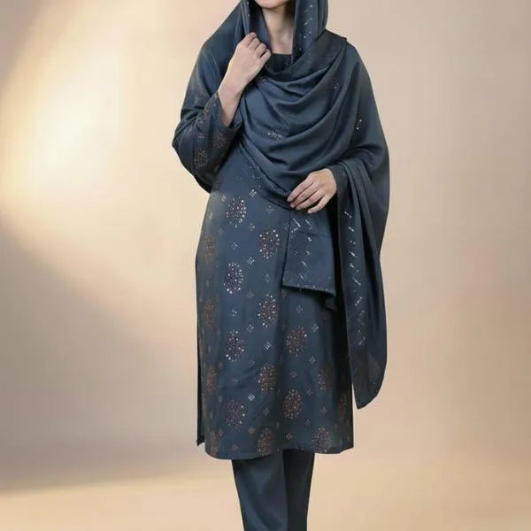 Woman wearing a dark blue outfit with a patterned top and plain bottom against a beige background