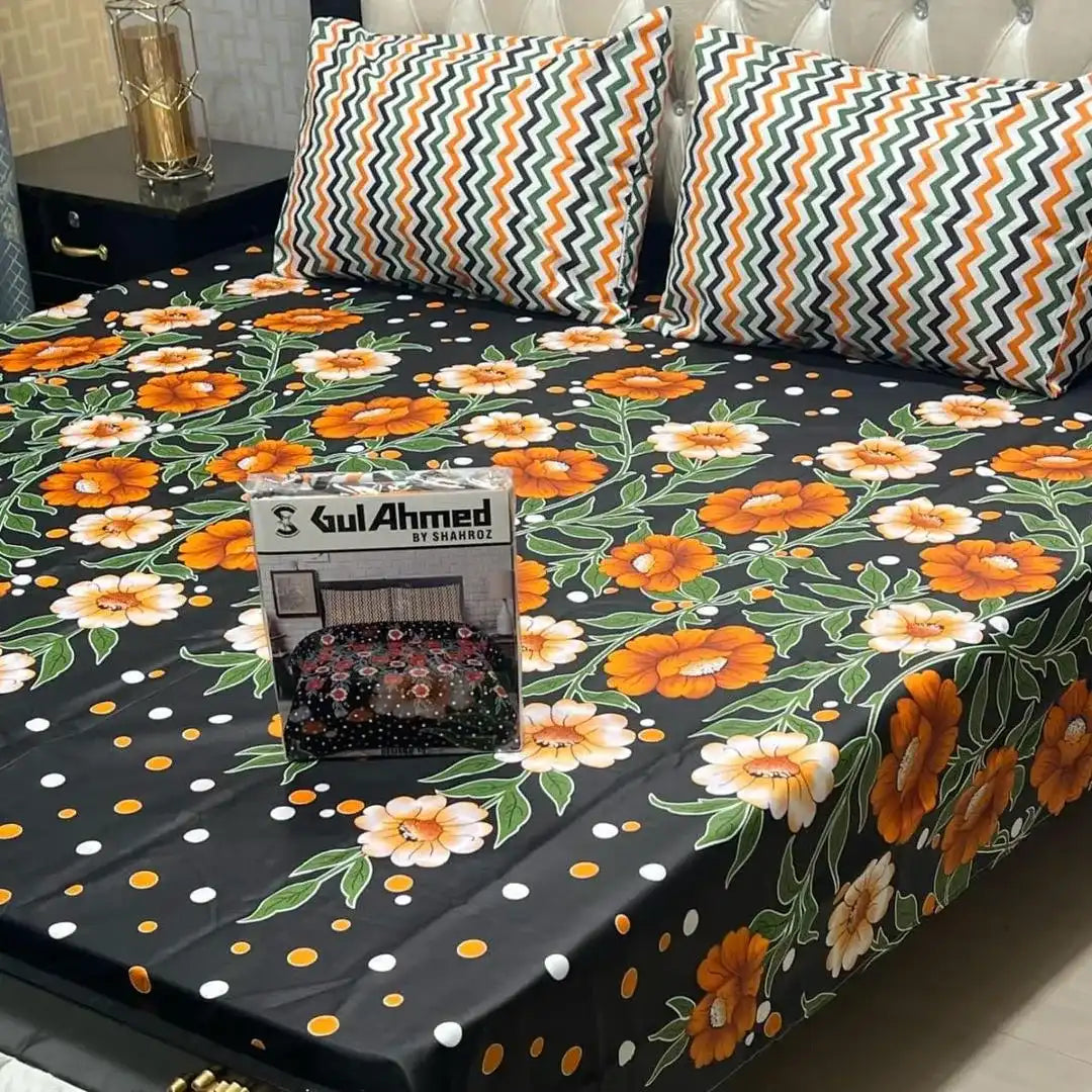 Floral patterned bedsheet with orange flowers on a black background, featuring Gul Ahmed branding.