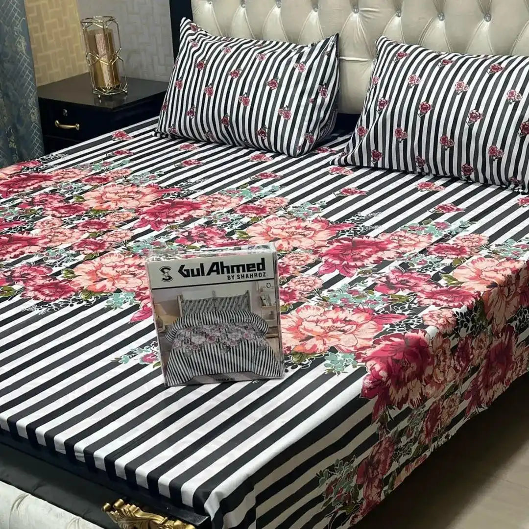 Floral and striped bedspread with a packaging box on a bed