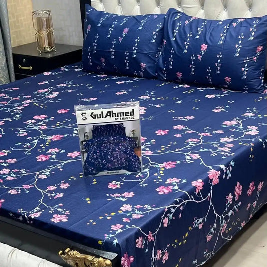 Floral patterned bedspread with a Gul Ahmed packaging on a bed