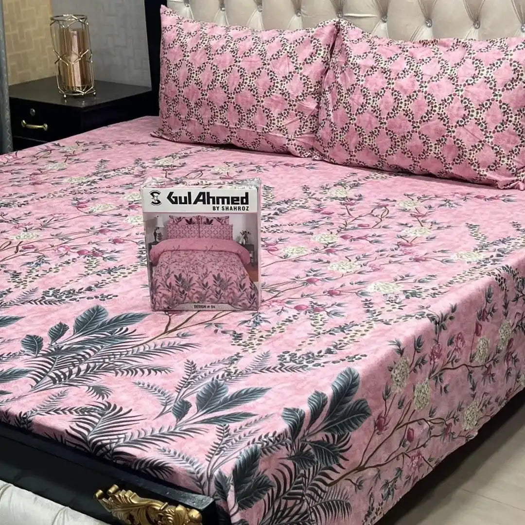 Pink floral bedspread with 'Gul Ahmed' packaging on a bed