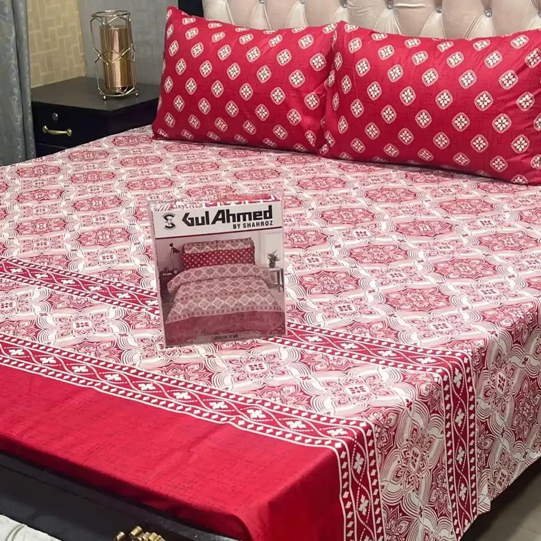 Red and white patterned bedspread with a box of Gul Ahmed on a bed.