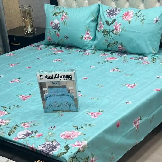 Floral bedsheet set with matching pillows on a bed, featuring a Gul Ahmed product packaging.