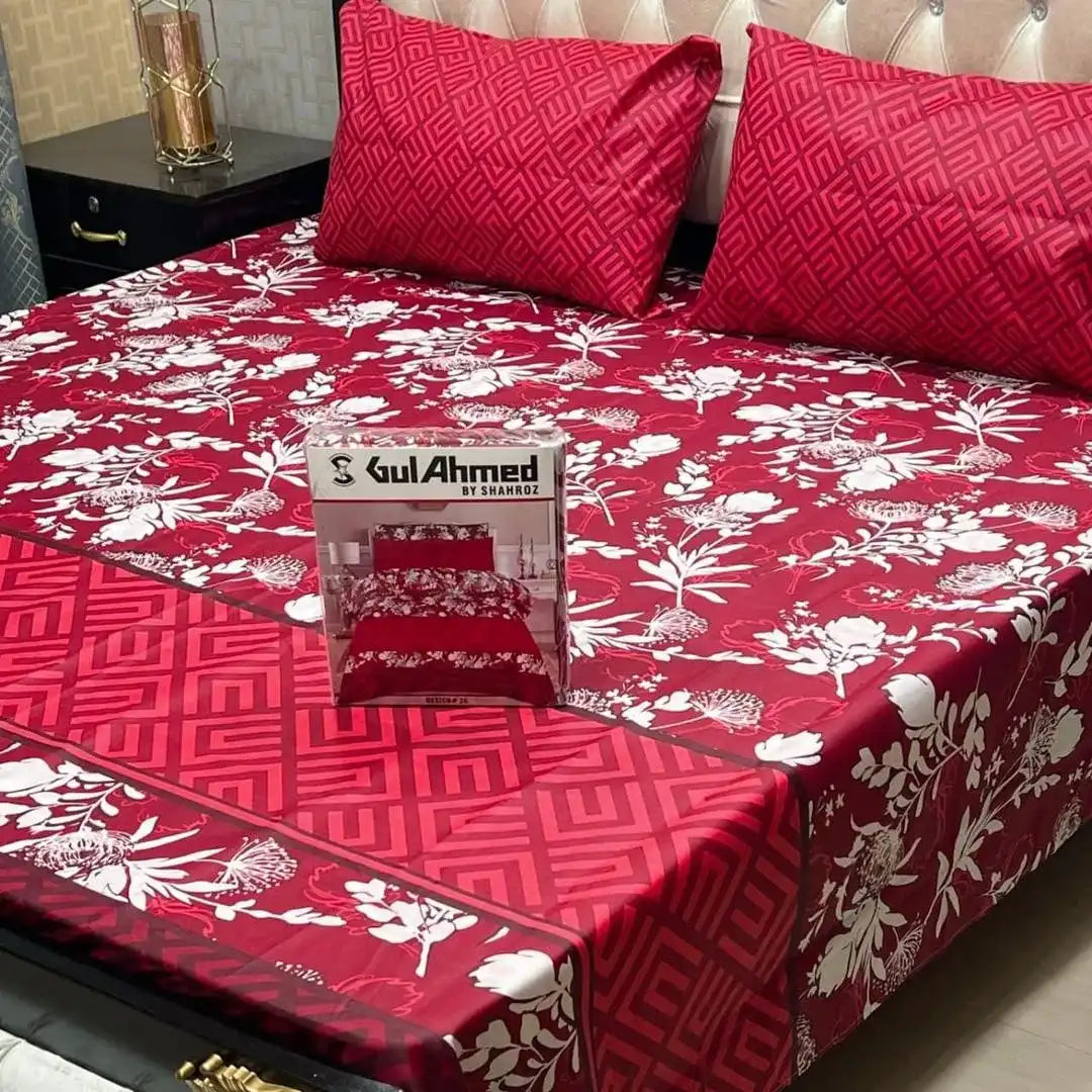 Red floral bedspread with a box of Gul Ahmed on a bed