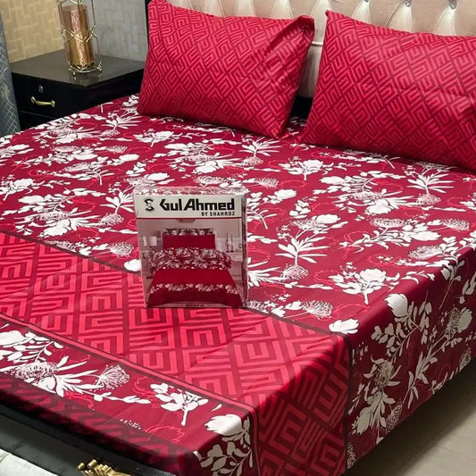 Red floral bedspread with a box of Gul Ahmed on a bed