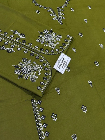 Green fabric with intricate black and white embroidery, featuring a visible brand label.