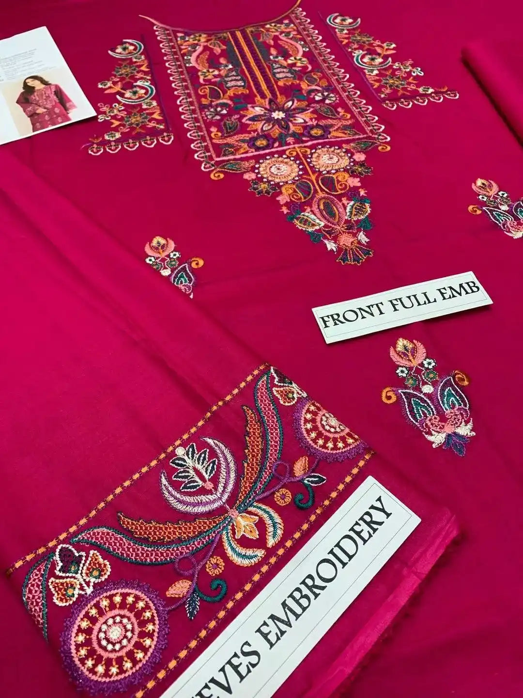 Embroidered fabric with intricate patterns on a pink background