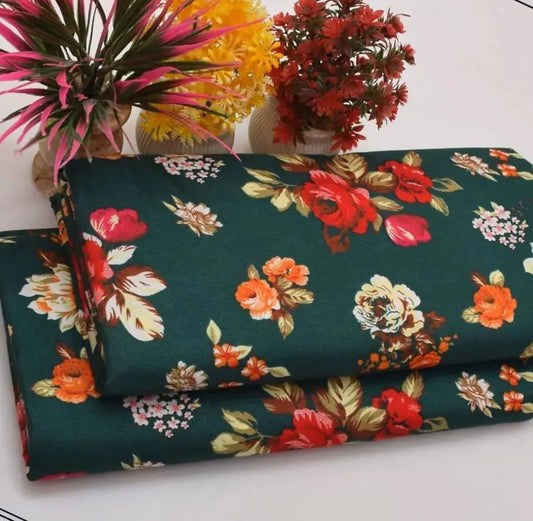 Floral fabric with red, orange, and pink flowers on a green background, with decorative plants in the background.