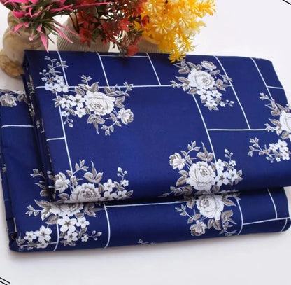 Roll of blue fabric with white floral patterns on a white background