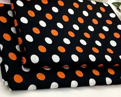 Black fabric with orange and white polka dots