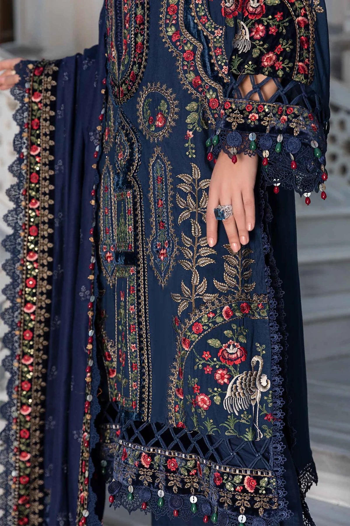 Navy blue embroidered garment with floral patterns and red accents.