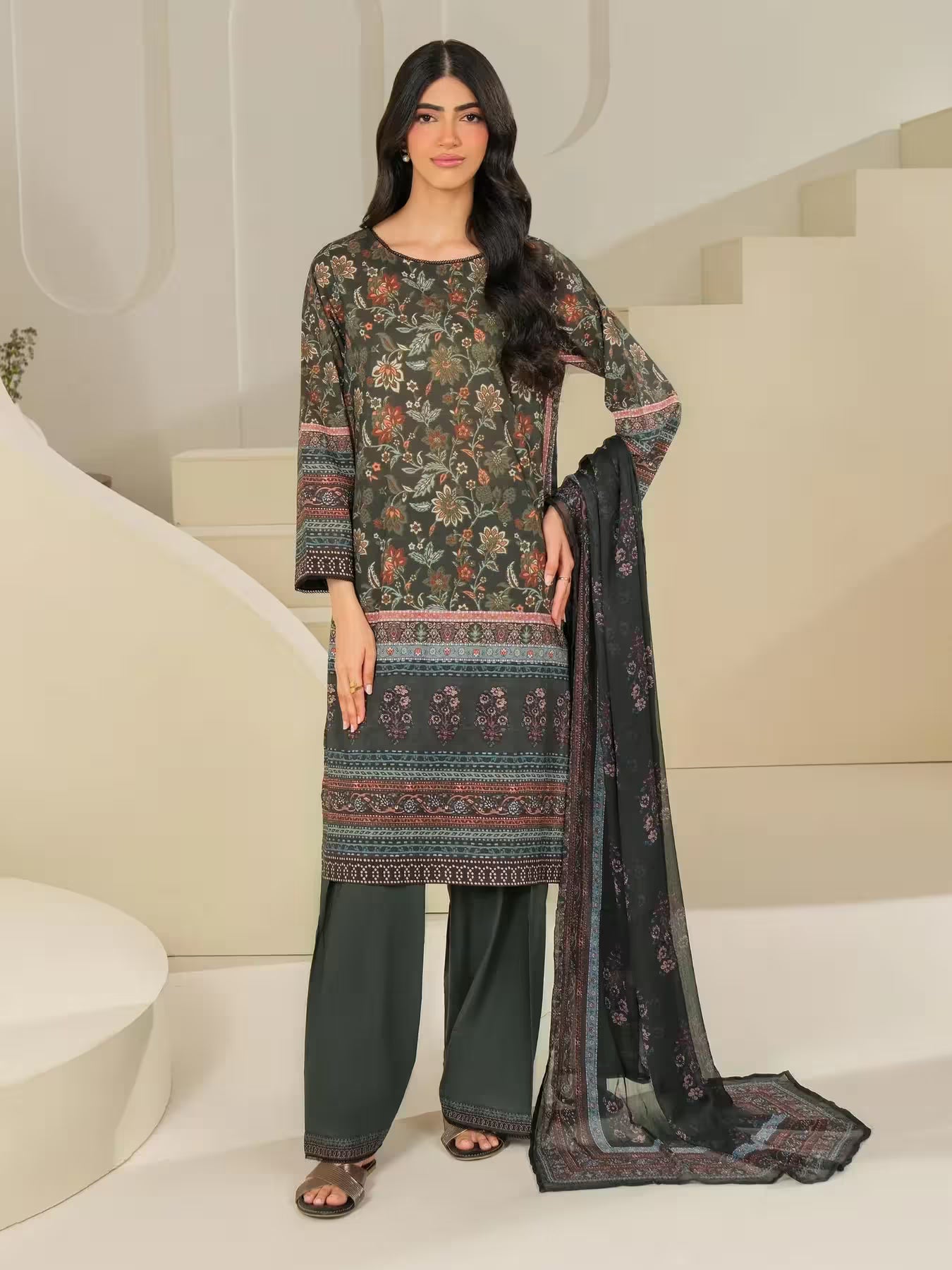 Woman wearing a floral dress with a dupatta in an indoor setting