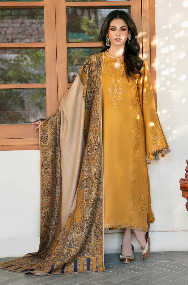 Woman in mustard yellow dress with a patterned dupatta standing indoors.