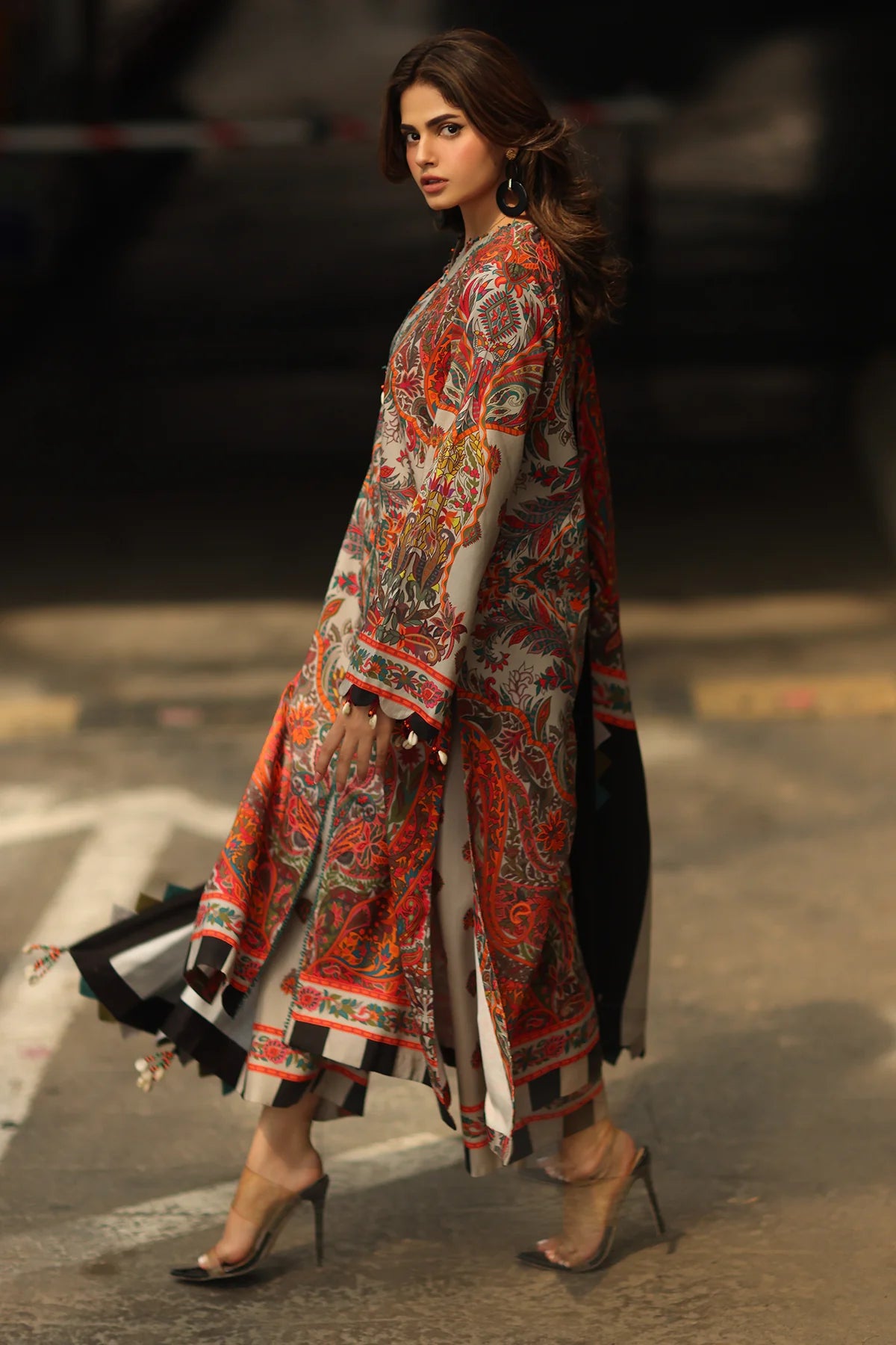 Woman wearing a colorful traditional outfit on a blurred street background
