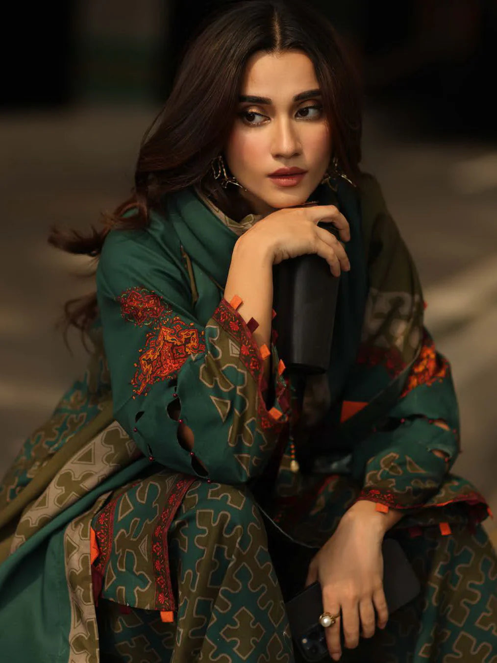 Woman wearing a traditional outfit with intricate patterns and embroidery.