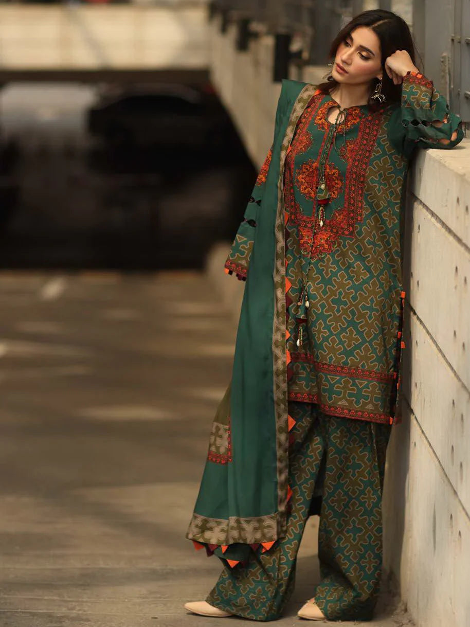 Woman in traditional embroidered outfit standing against a wall.