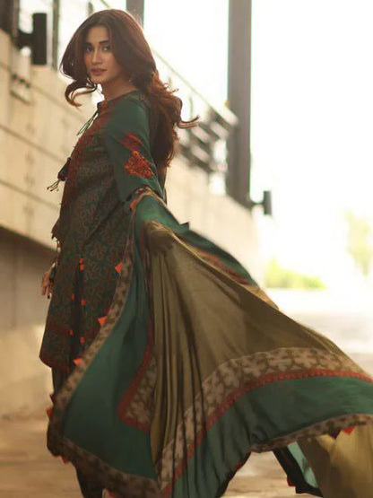 Woman wearing a traditional outfit with a green and brown patterned dress.
