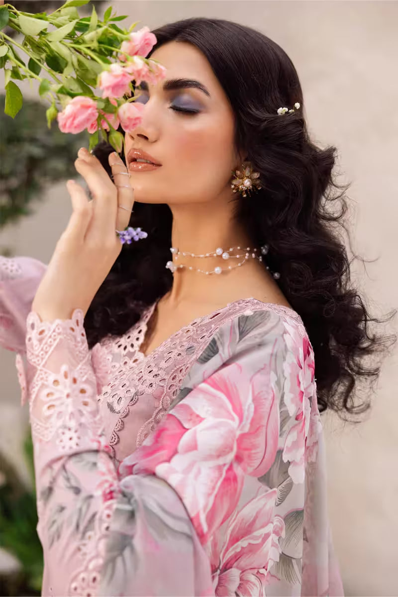 Woman in a floral dress holding pink flowers against a blurred natural background