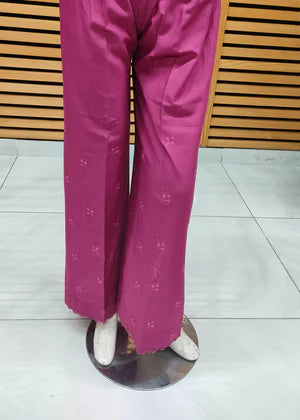 Pink pants on a mannequin against a wooden panel background