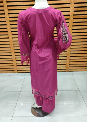 Pink traditional outfit with embroidery on a wooden background
