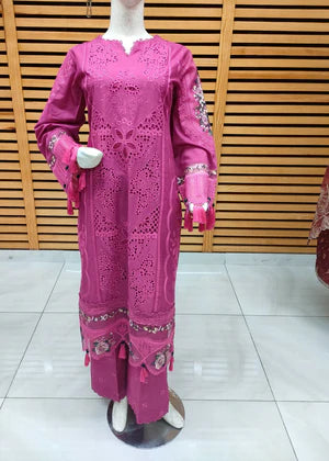 Mannequin wearing a pink traditional outfit with embroidery against a wooden panel background