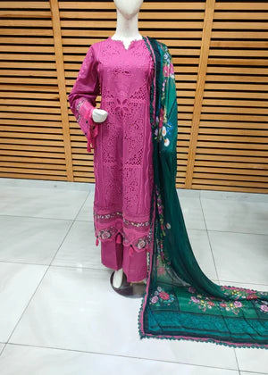Mannequin wearing a pink embroidered outfit with a green dupatta against a wooden panel background